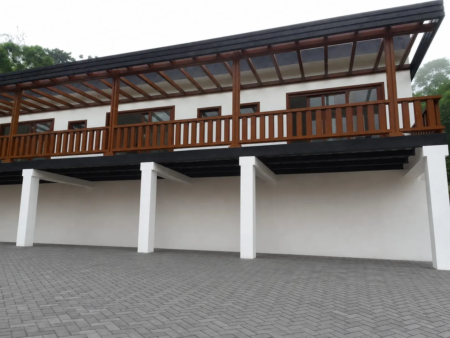 Vivienda de dos plantas con balcon de madera, pergola y parqueadero cubierto